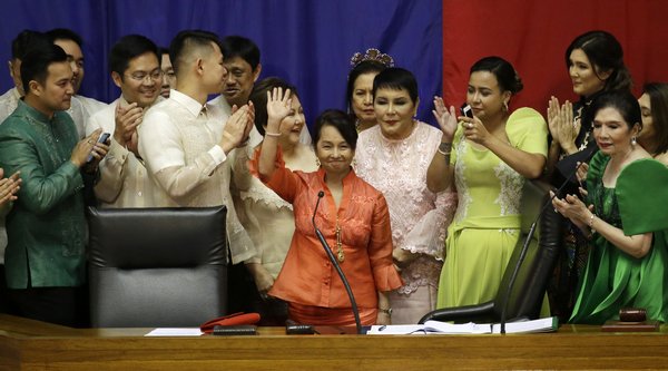 Pampanga Representative and former President Gloria Macapagal-Arroyo, waves at the plenary hall of the House of Representatives together with other allied legislators. /AP Photo/ Cebu Daily News