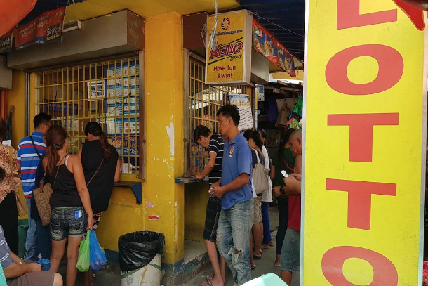 People line up to buy lottery tickets ahead of the "Ultra Lotto" draw that carries a US$14 million jackpot on Sept. 28. (Photo by Karl Romano)